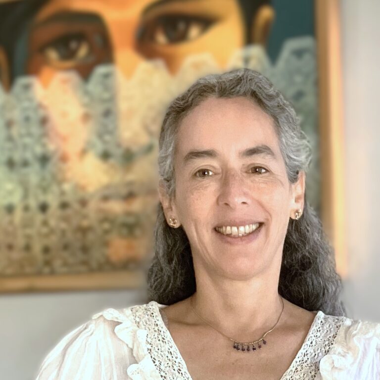 Woman standing in front of a vibrantly colored painting of a face