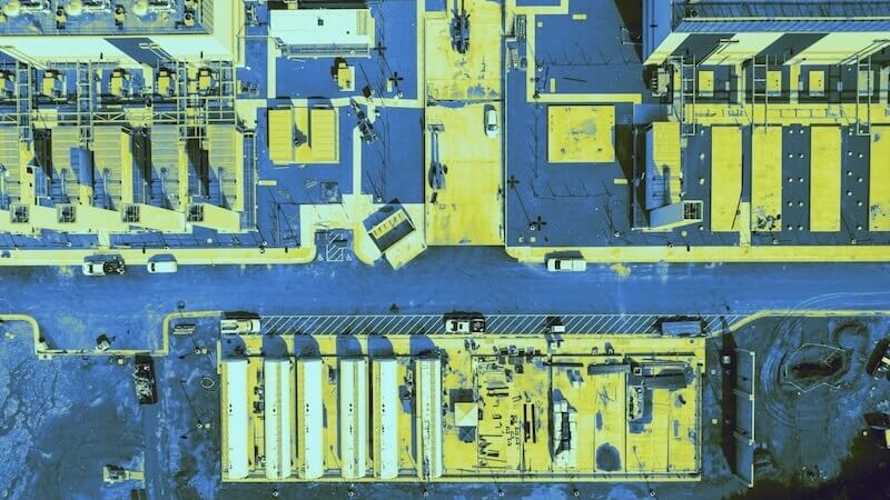 Aerial view of a large data center, colorized in yellows and blues